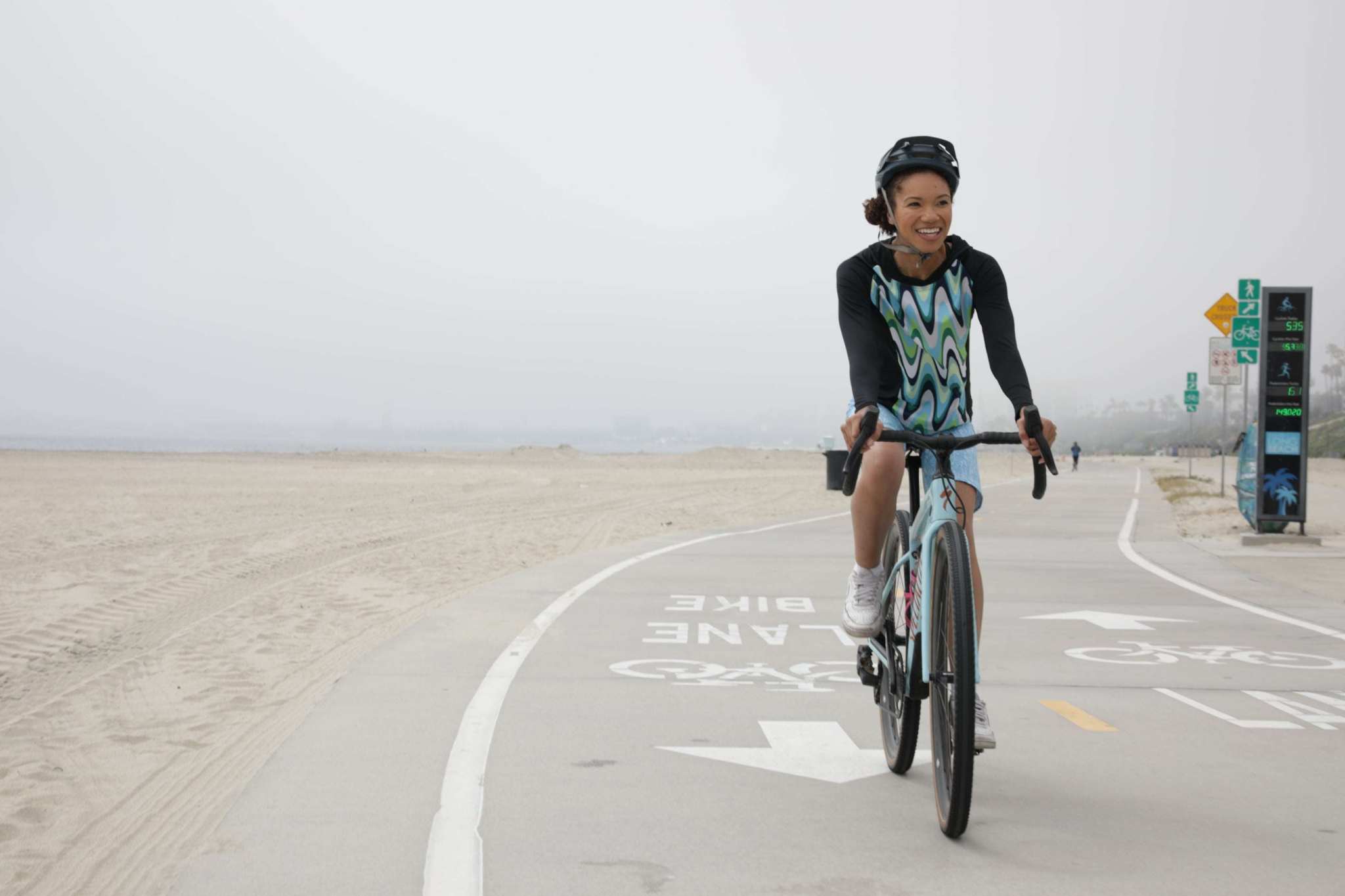 Moxie Hoodie High Visibility Color Wave for cycling on a coastal path.